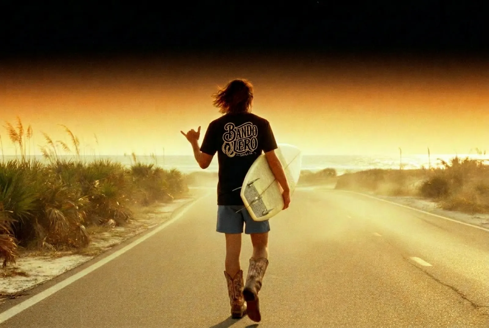 A figure on an empty coastal highway at golden hour